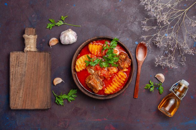 Vista superior da sopa saborosa do molho de carne com verduras e batatas fatiadas no preto