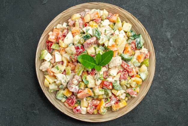 Foto grátis vista superior da tigela de salada de legumes no centro com verde sobre fundo verde escuro