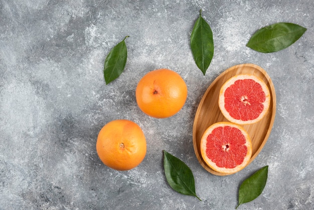 Vista superior da toranja orgânica inteira ou parcialmente cortada com folhas.