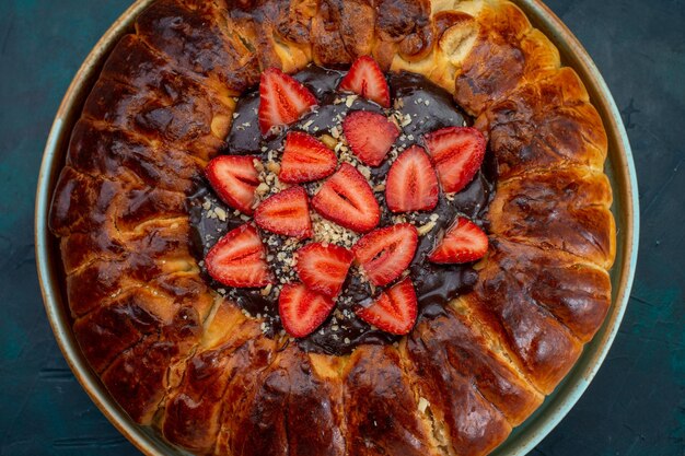 Vista superior da torta de morango com geleia e morangos frescos na superfície azul