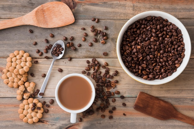Foto grátis vista superior da xícara de café com grãos e colheres