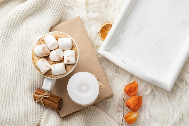 Vista superior da xícara de chocolate quente no livro com marshmallows e vela