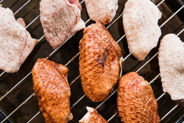 Foto grátis vista superior das asas de frango cru na grelha de metal