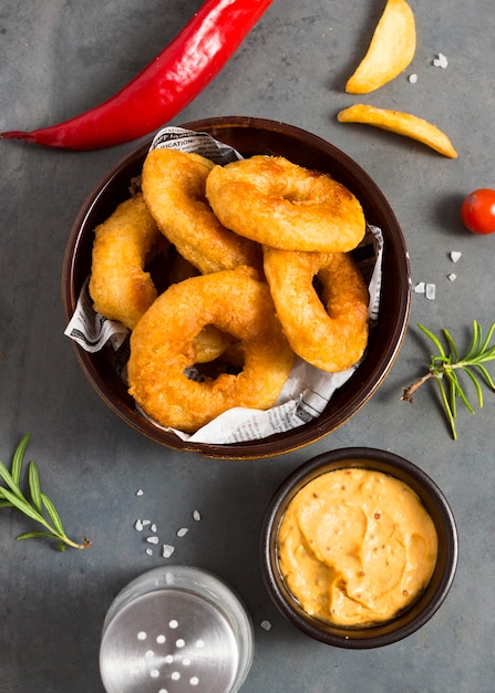 Vista superior das batatas fritas em uma tigela com sal e mostarda