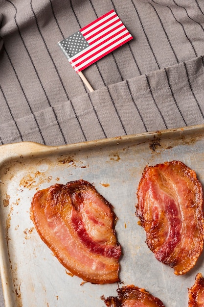 Vista superior das fatias de bacon na bandeja com a bandeira americana