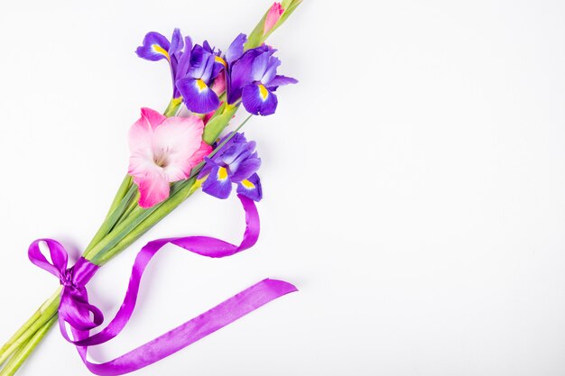 Vista superior das flores de íris e gladíolo de cor roxa e rosa escura, isoladas no fundo branco, com espaço de cópia