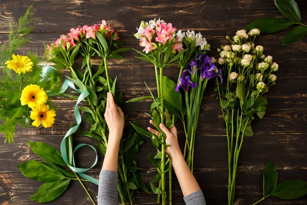 Vista superior das flores, florista em processo de fazer buquê