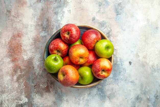 Vista superior das maçãs vermelhas e verdes em uma tigela no local da cópia da superfície nua