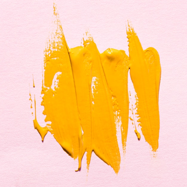 Foto grátis vista superior das pinceladas de tinta amarela na superfície