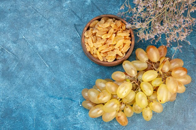 Vista superior das uvas frescas com passas na mesa azul