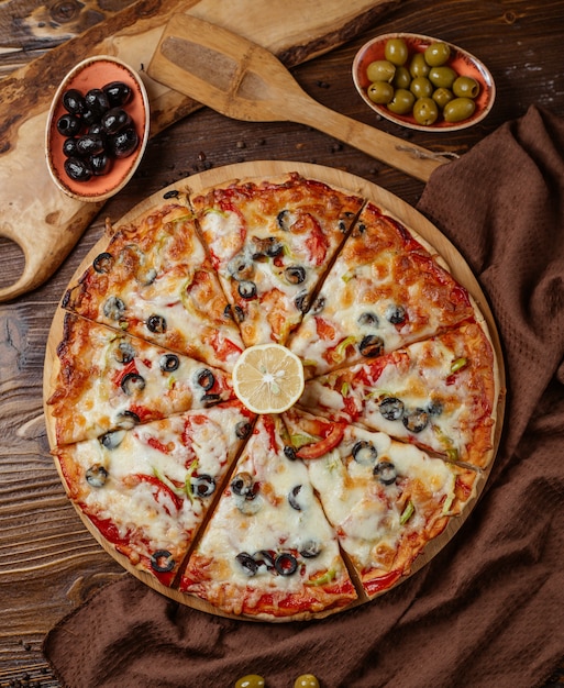 vista superior de 8 peças de pizza mista com azeitona, tomate, pimentão