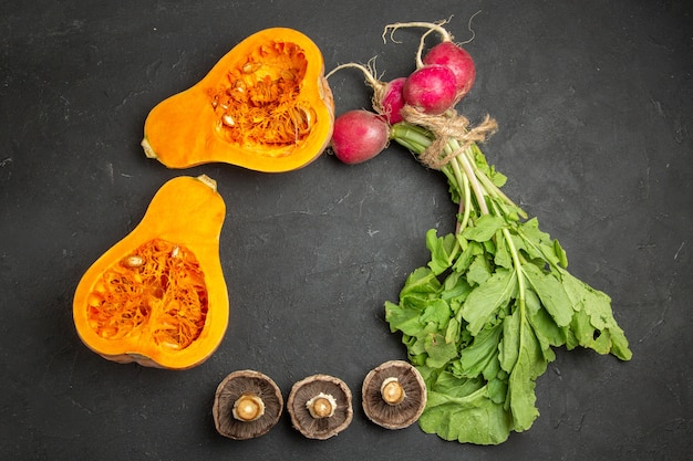 Foto grátis vista superior de abóbora fresca com verduras e rabanete em comida de piso escuro