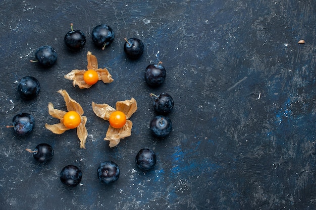 vista superior de abrunheiros frescos alinhados em círculo na mesa escura, vitamina alimentar de frutas frescas