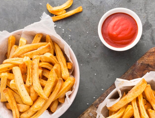 Vista superior de batatas fritas em uma tigela com molho de ketchup