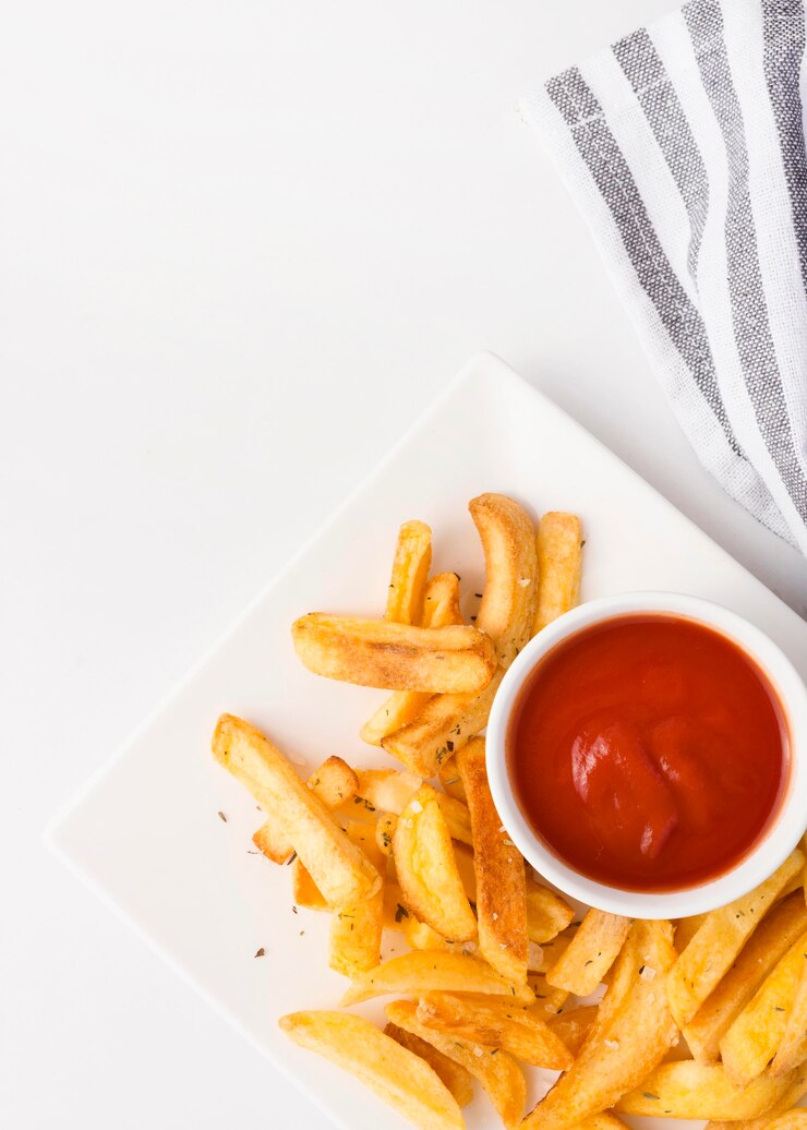 Foto grátis vista superior de batatas fritas no prato com ketchup e copie o espaço