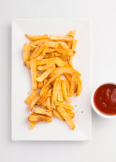 Vista superior de batatas fritas no prato com molho de ketchup