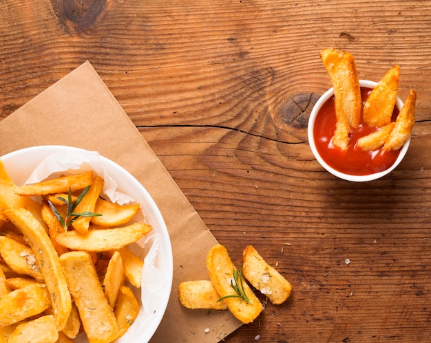 Vista superior de batatas fritas no prato com tigela de ketchup