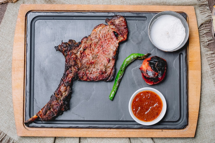 Foto grátis vista superior de bife grelhado com legumes grelhados com ketchup e maionese