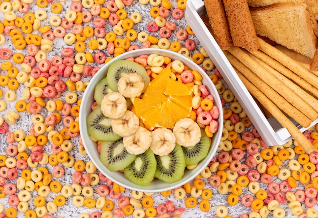 Foto grátis vista superior de biscoitos com anéis de milho e frutas na superfície branca horizontal