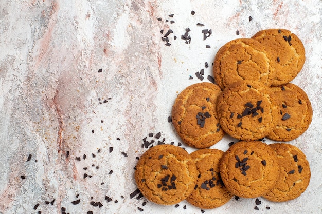 Vista superior de biscoitos de areia deliciosos, doces perfeitos para chá na superfície branca