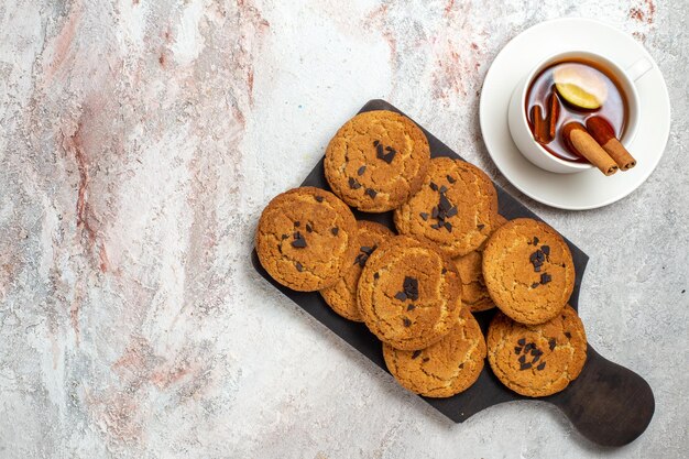 Vista superior de biscoitos de areia deliciosos, doces perfeitos para uma xícara de chá na superfície branca