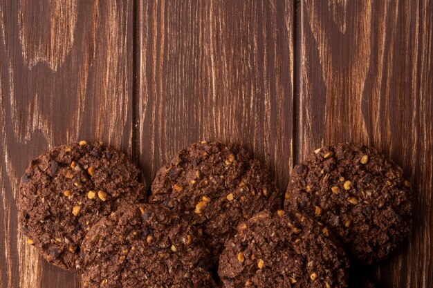 Vista superior de biscoitos de chocolate com nozes cereais e cacau na madeira