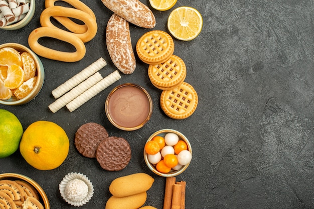 Foto grátis vista superior de biscoitos doces com biscoitos e frutas em fundo cinza