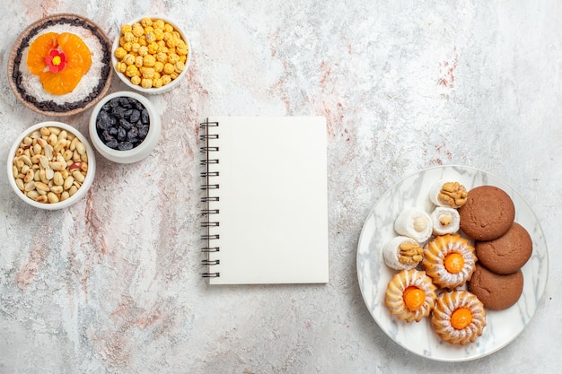 Vista superior de biscoitos doces com nozes e sobremesa em branco