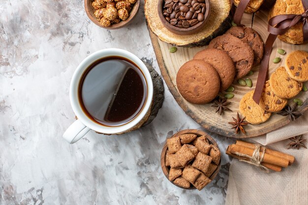 Vista superior de biscoitos doces com nozes e xícara de café na mesa de luz