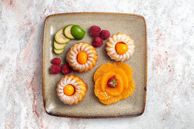 Vista superior de bolinhos deliciosos com frutas fatiadas em branco