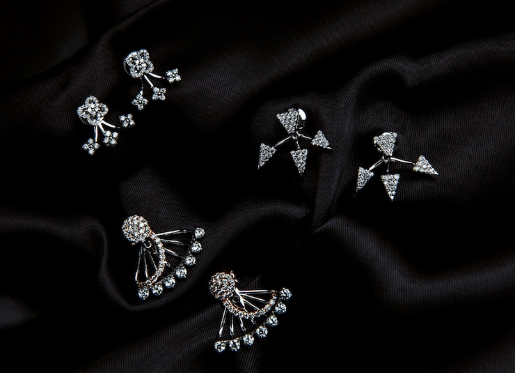 Foto grátis vista superior de brincos de prata esterlina com cristal swarovski com tachas na parede preta