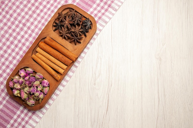 Foto grátis vista superior de canela fresca com flores na cor da planta de flor de mesa branca