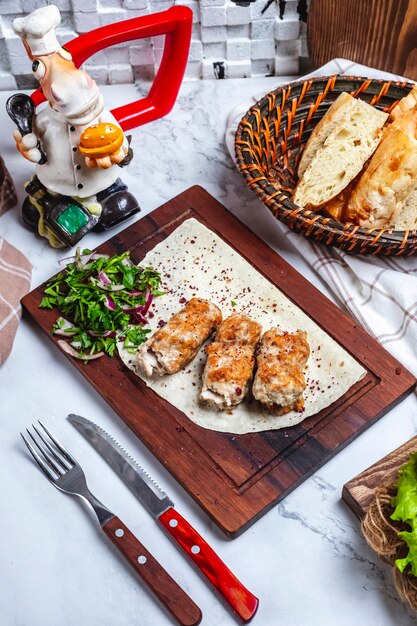 Vista superior de carne lula kebab no pão pita com ervas e cebola em uma placa