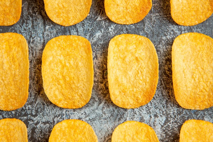 Foto grátis vista superior de cinco chips assados crocantes alinhados em linhas sobre um fundo cinza