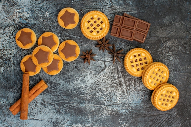 Foto grátis vista superior de cookies de layout em forma de crescente com canela e chocolate em fundo cinza
