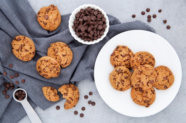 Vista superior de cookies e gotas de chocolate em um pano