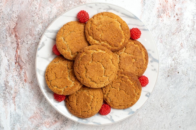Foto grátis vista superior de deliciosos biscoitos de açúcar dentro do prato na superfície branca