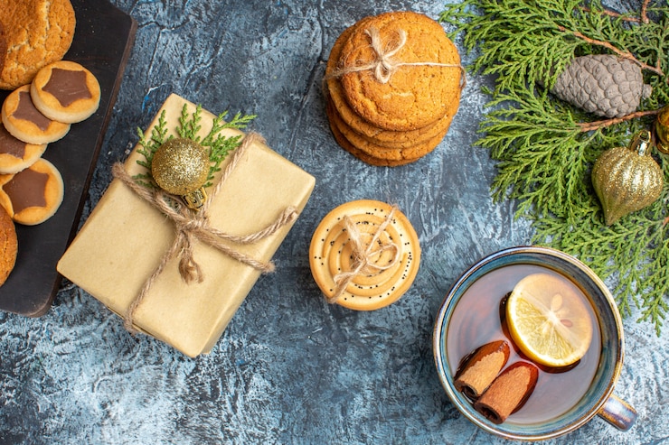 Foto grátis vista superior de diferentes biscoitos doces com presente e xícara de chá sobre fundo claro