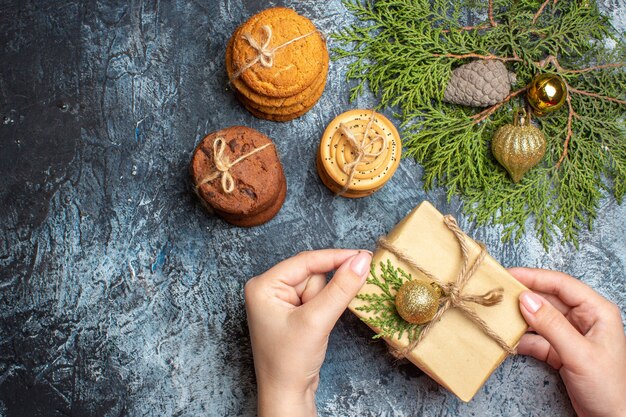 Vista superior de diferentes biscoitos doces com presente em uma mesa leve