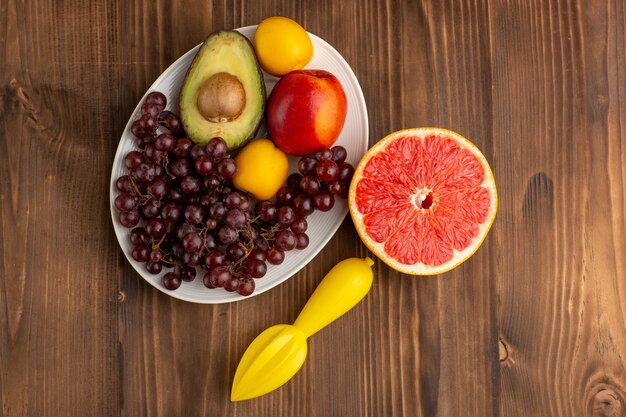 Vista superior de diferentes frutas com toranja na mesa de madeira marrom