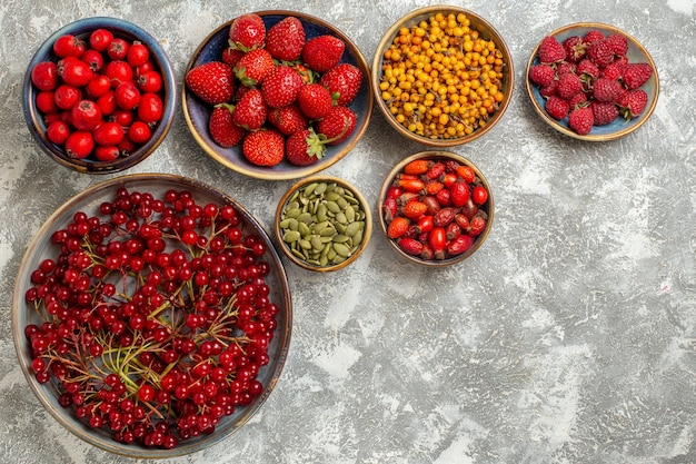 Vista superior de diferentes frutas frescas dentro de pratos em fundo branco