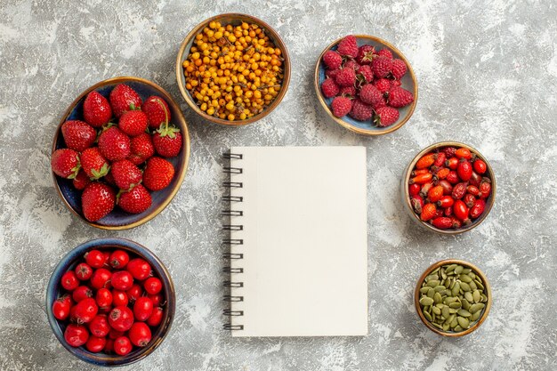 Vista superior de diferentes frutas frescas dentro de pratos em fundo branco