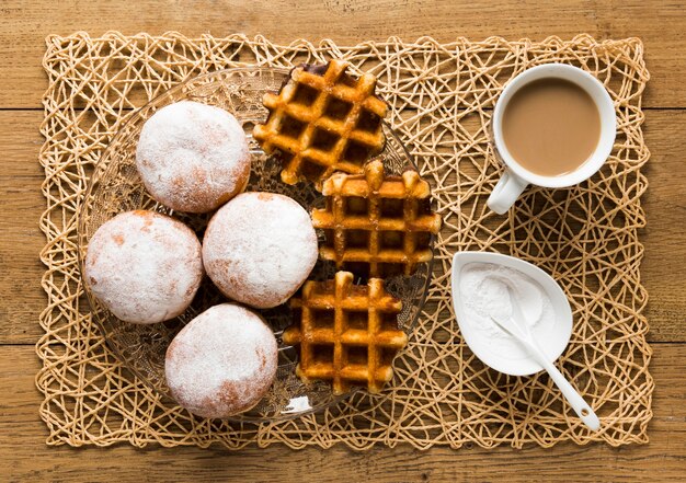 Vista superior de donuts com açúcar em pó e waffles