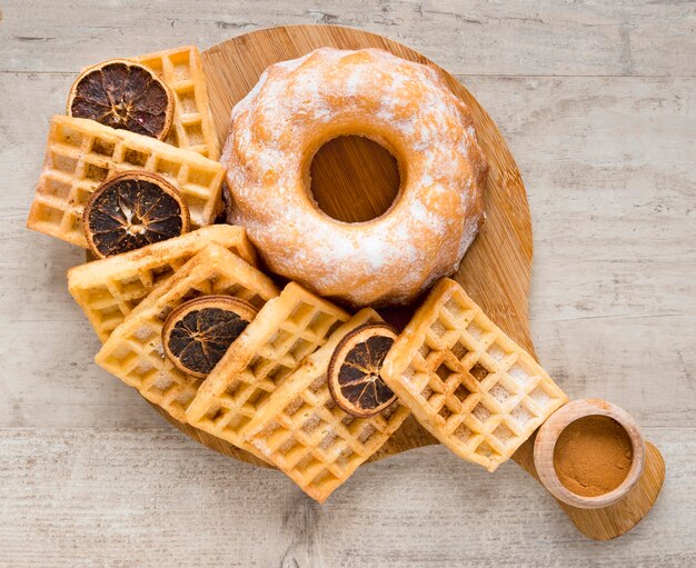 Vista superior de donuts com waffles e frutas cítricas secas
