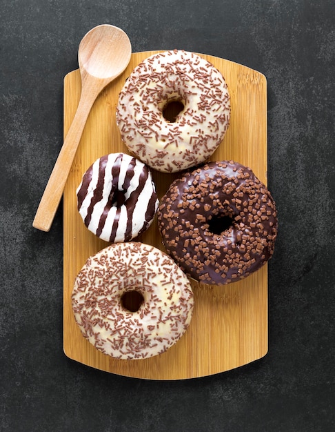 Foto grátis vista superior de donuts na tábua com colher