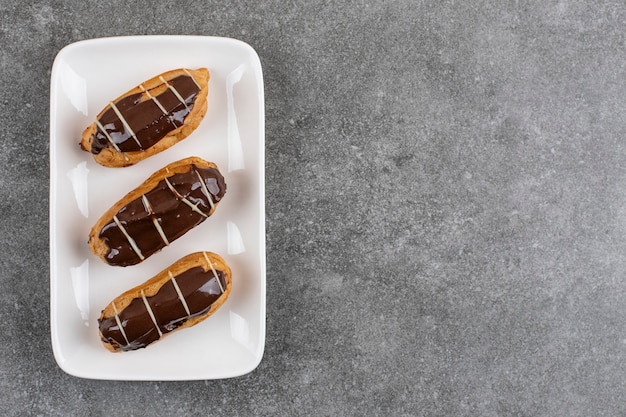 Vista superior de éclairs de chocolate caseiros frescos na superfície branca