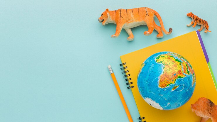 Foto grátis vista superior de estatuetas de animais com caderno e planeta terra para o dia animal