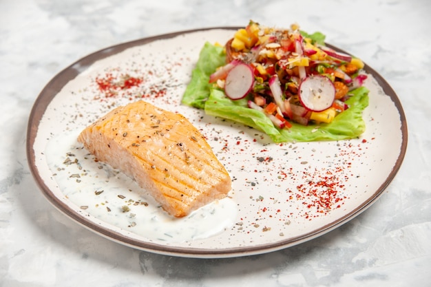 Vista superior de farinha de peixe e salada em um prato em superfície branca manchada