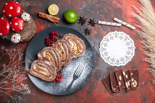 Vista superior de fatias de bolo de rolos de biscoito na superfície escura