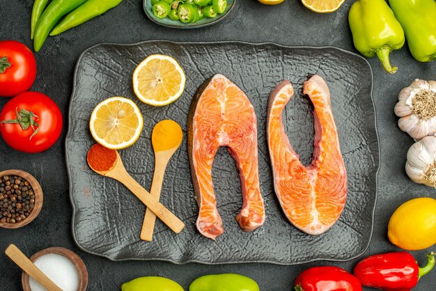 Vista superior de fatias de carne frita com legumes frescos em fundo escuro